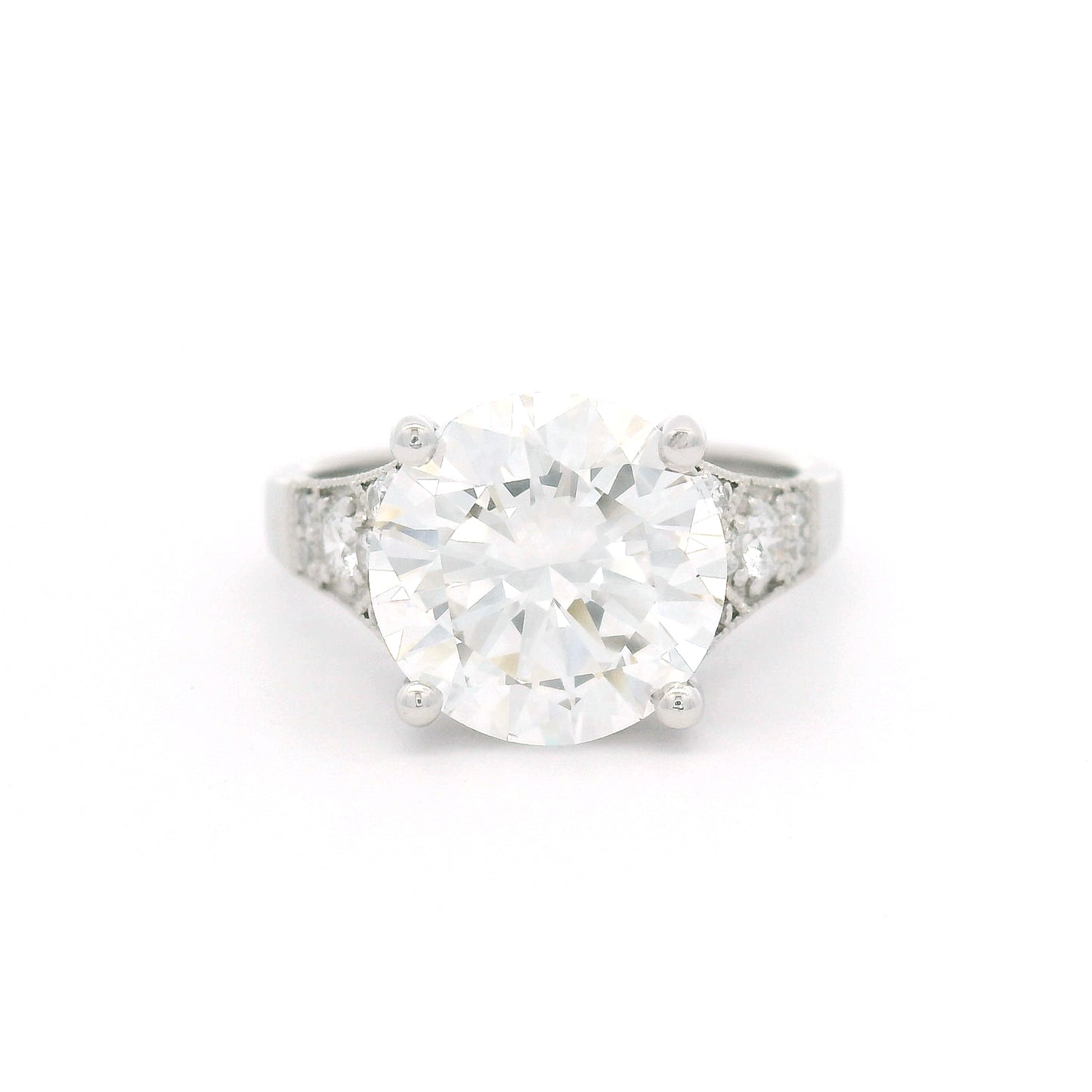14K white gold engagement ring with a claw-set 4.05ct lab-grown round brilliant-cut diamond and six bead-set lab-grown diamond accents on each shoulder with milgrain edges.