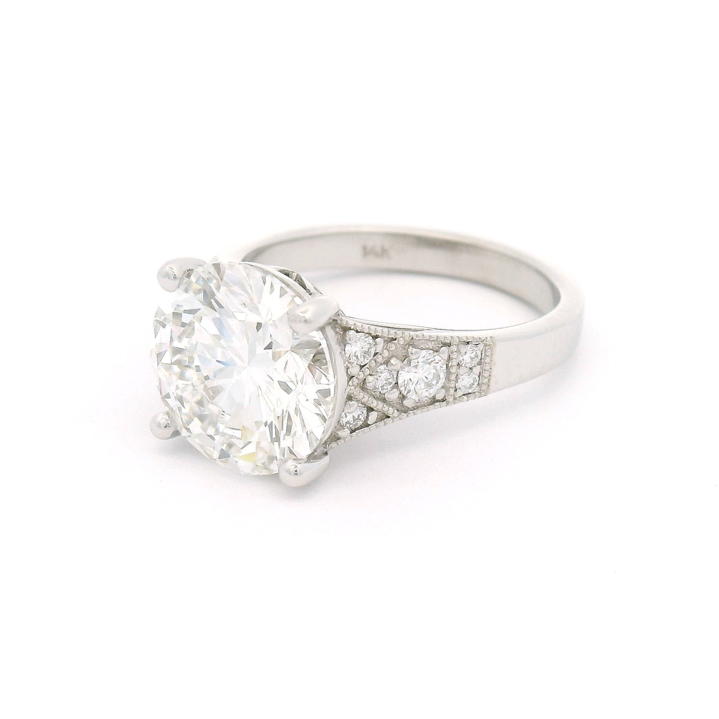 14K white gold engagement ring with a claw-set 4.05ct lab-grown round brilliant-cut diamond and six bead-set lab-grown diamond accents on each shoulder with milgrain edges.
