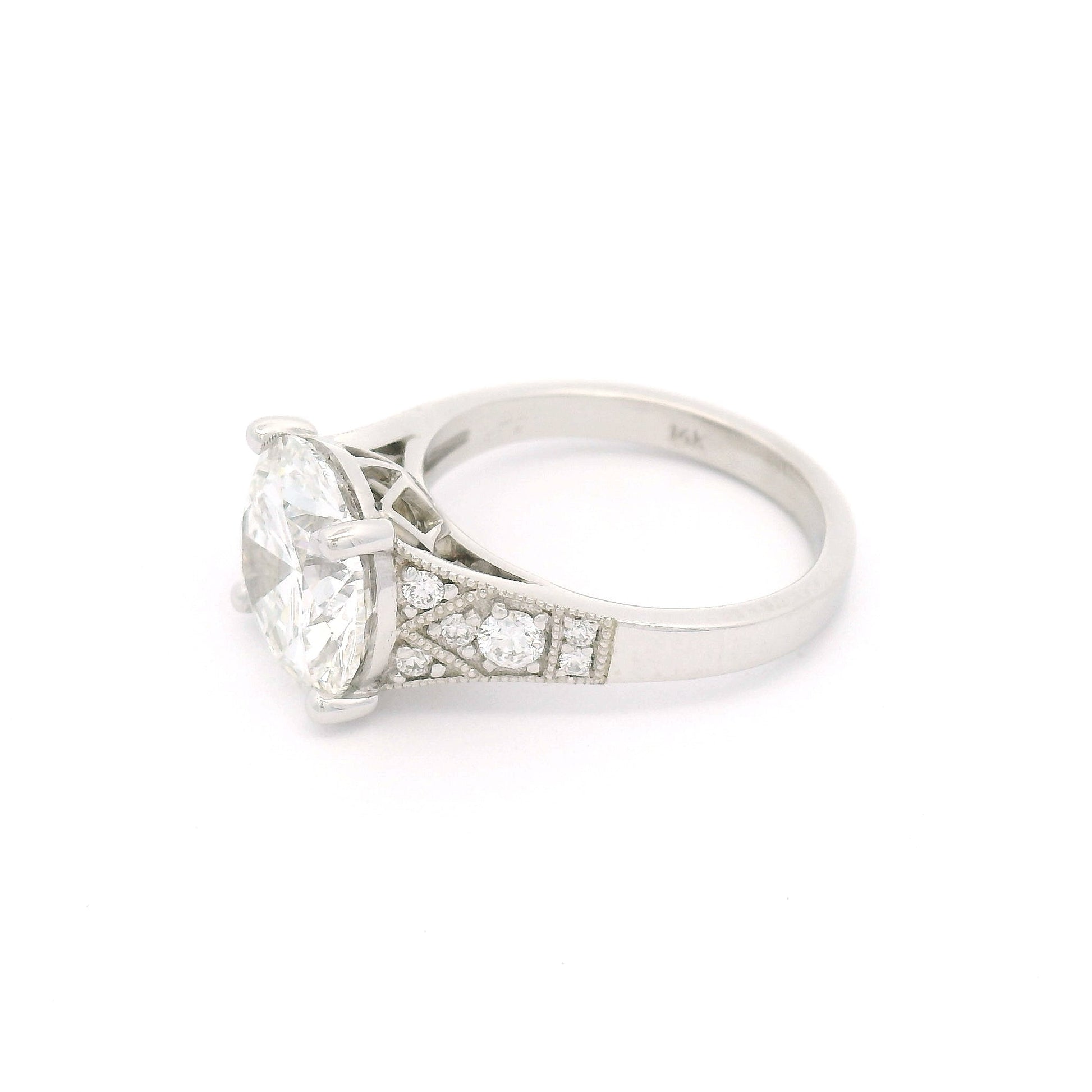 14K white gold engagement ring with a claw-set 4.05ct lab-grown round brilliant-cut diamond and six bead-set lab-grown diamond accents on each shoulder with milgrain edges.