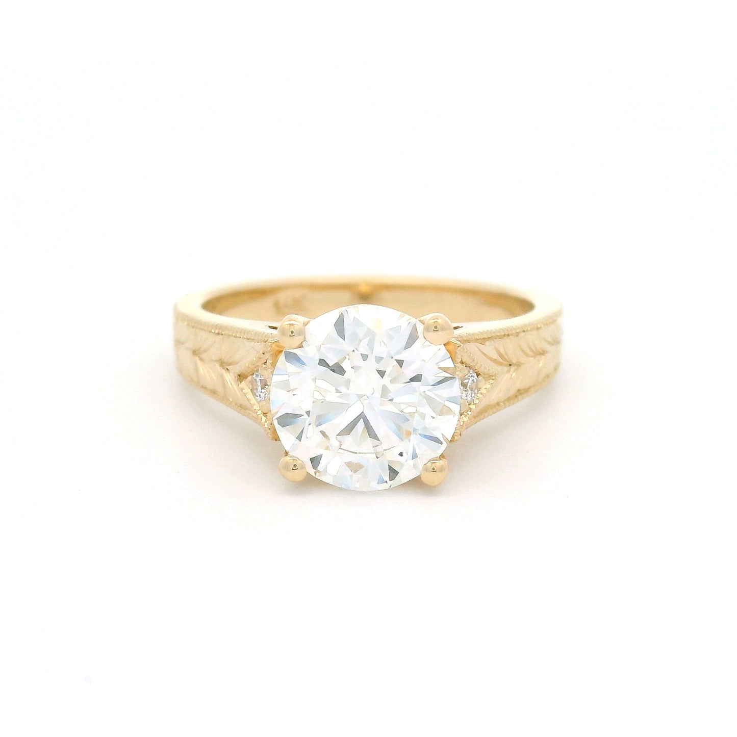 14K yellow gold engagement ring featuring a claw-set 2.05ct lab-grown round brilliant-cut diamond with bead-set diamond accents, hand-engraved wheat pattern and milgrain edges.