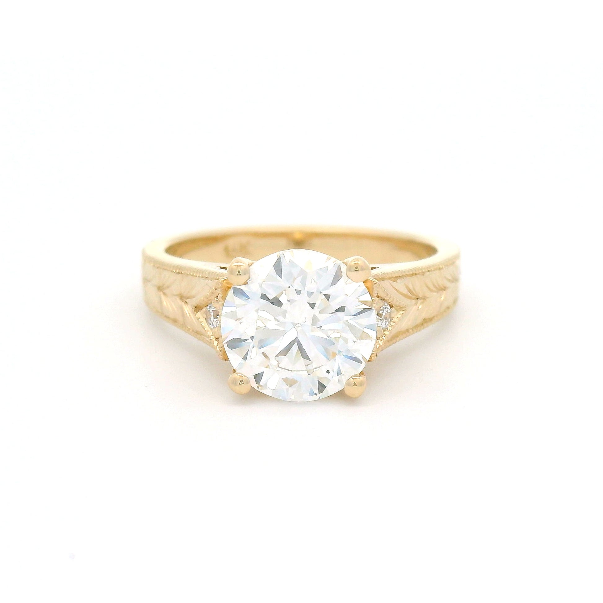 14K yellow gold engagement ring featuring a claw-set 2.05ct lab-grown round brilliant-cut diamond with bead-set diamond accents, hand-engraved wheat pattern and milgrain edges.