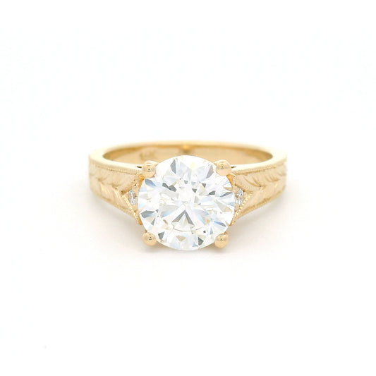 14K yellow gold engagement ring featuring a claw-set 2.05ct lab-grown round brilliant-cut diamond with bead-set diamond accents, hand-engraved wheat pattern and milgrain edges.