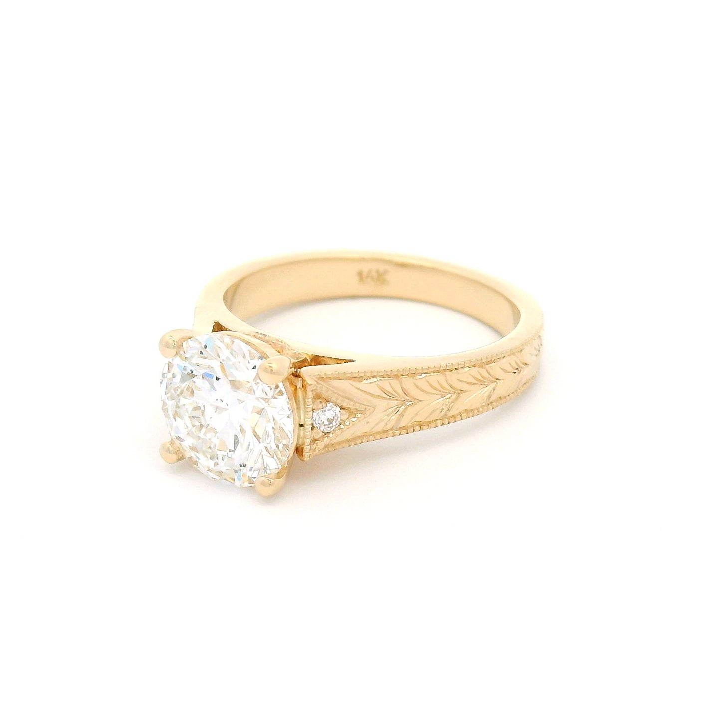 14K yellow gold engagement ring featuring a claw-set 2.05ct lab-grown round brilliant-cut diamond with bead-set diamond accents, hand-engraved wheat pattern and milgrain edges.