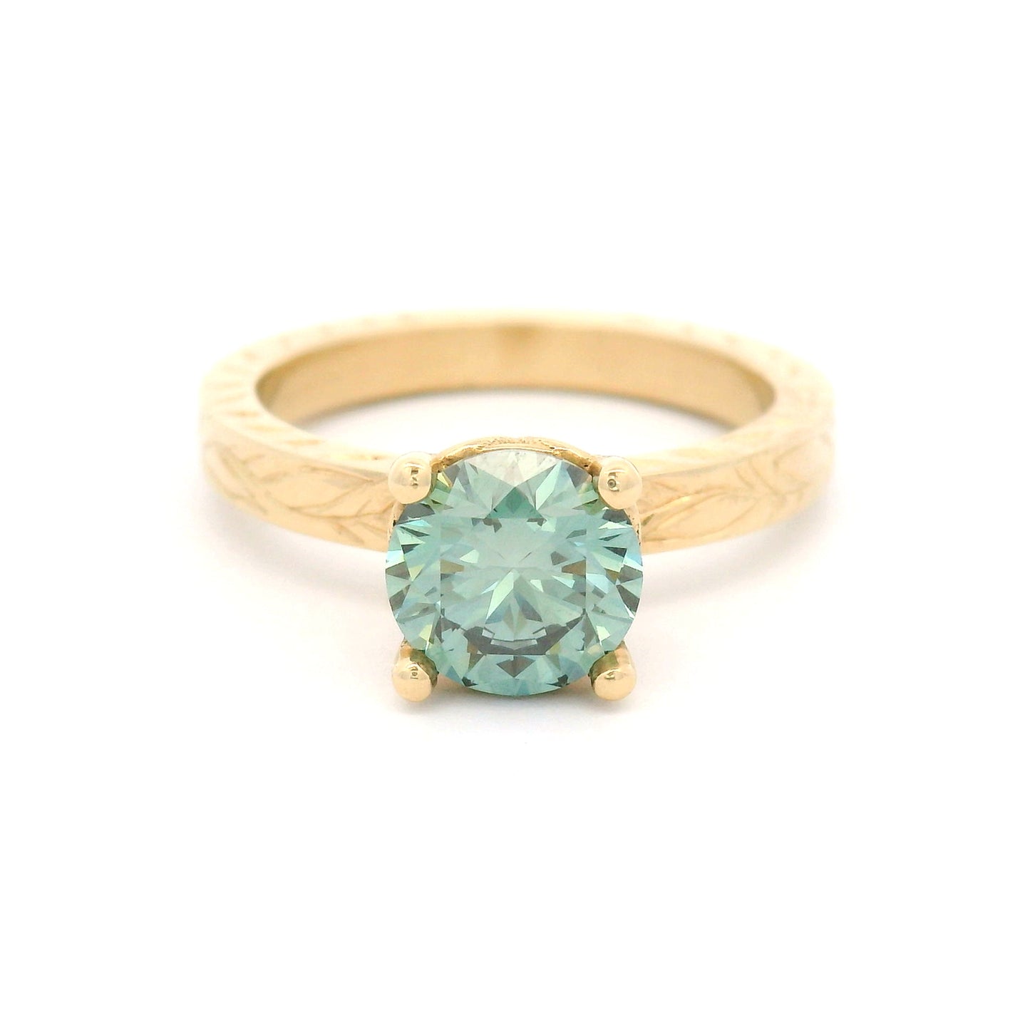 14K yellow gold solitaire engagement ring with 1.3ct lab-grown round brilliant Fancy Green diamond and hand-engraved vine and leaf pattern band.