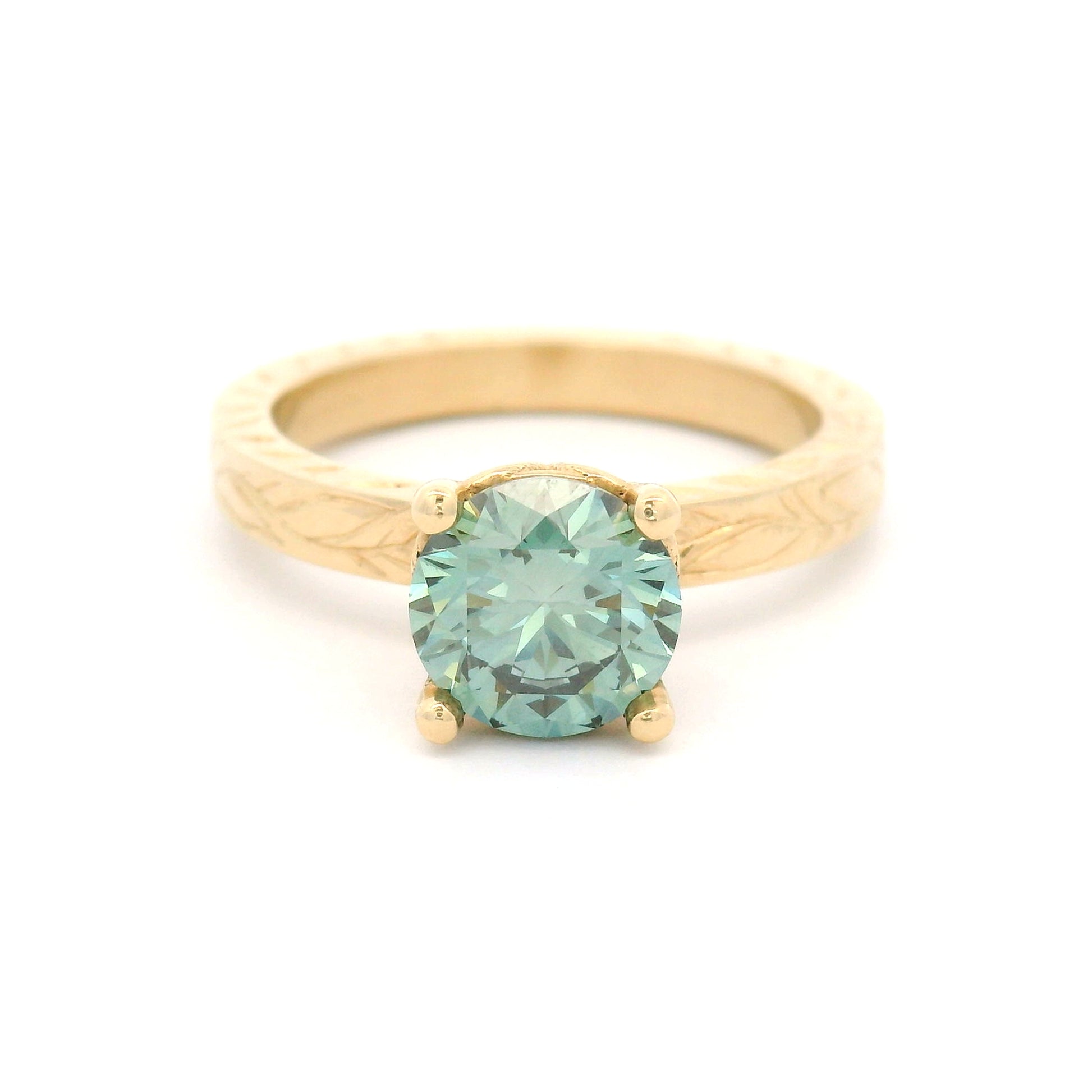 14K yellow gold solitaire engagement ring with 1.3ct lab-grown round brilliant Fancy Green diamond and hand-engraved vine and leaf pattern band.