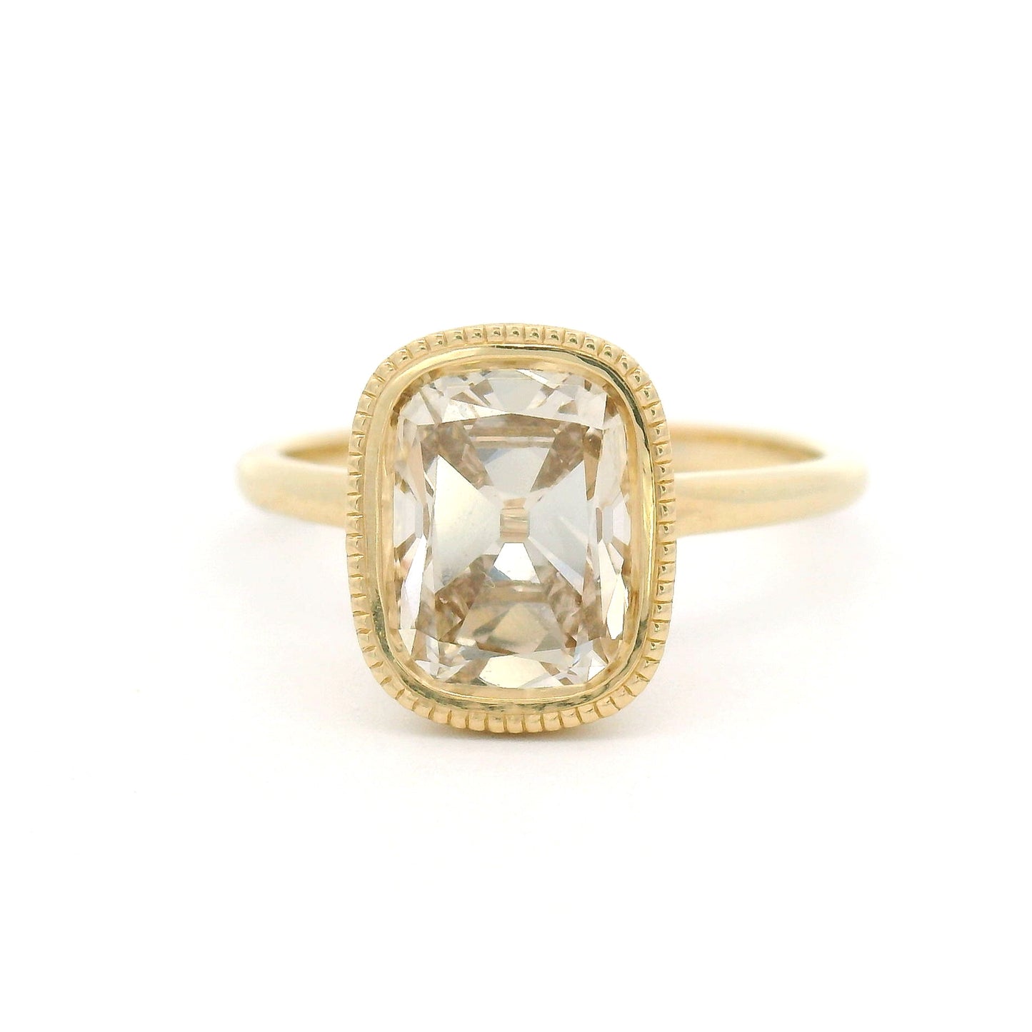 14K yellow gold solitaire engagement ring featuring a bezel-set 2.02ct lab-grown old mine-cut cushion diamond with VS2 clarity, R-S light brown colour, and a delicate milgrain edge.