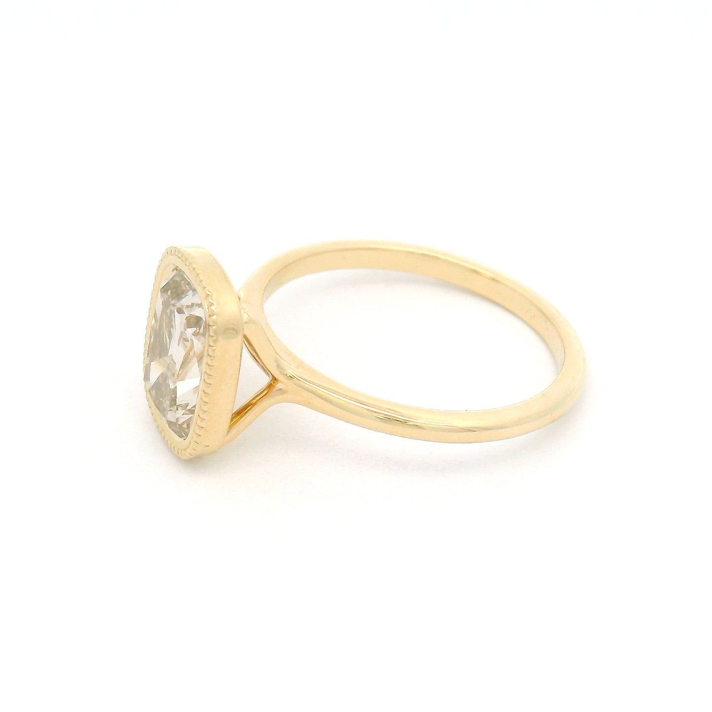 14K yellow gold solitaire engagement ring featuring a bezel-set 2.02ct lab-grown old mine-cut cushion diamond with VS2 clarity, R-S light brown colour, and a delicate milgrain edge.
