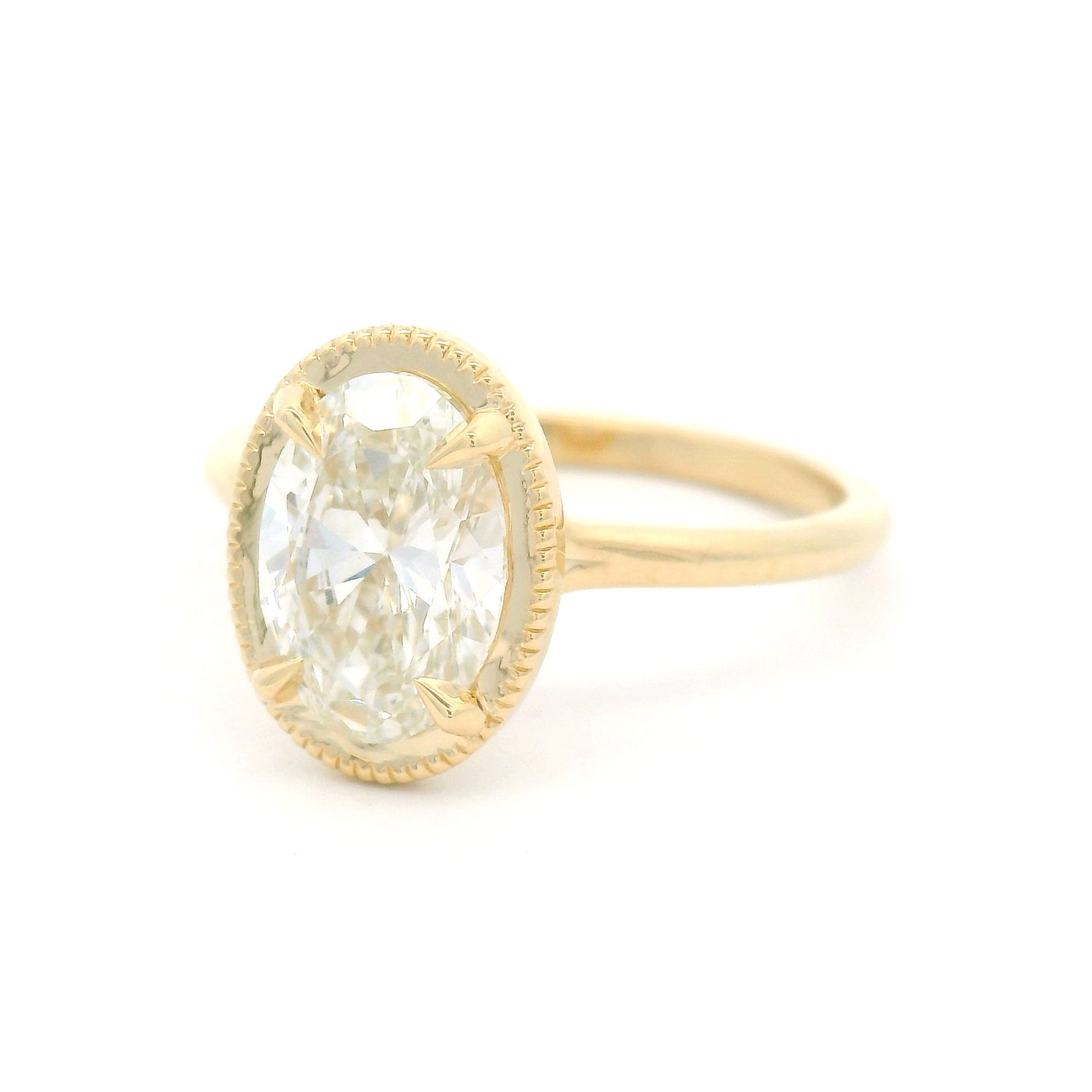 14K yellow gold solitaire engagement ring featuring a claw-set 1.54ct lab-grown oval brilliant-cut diamond with VVS2 clarity, H colour, and a delicate milgrain-edged setting.
