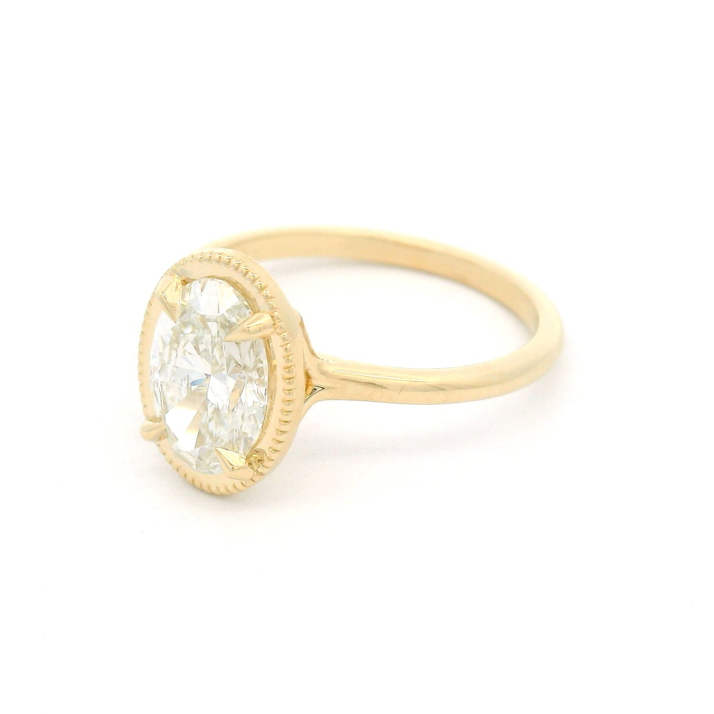14K yellow gold solitaire engagement ring featuring a claw-set 1.54ct lab-grown oval brilliant-cut diamond with VVS2 clarity, H colour, and a delicate milgrain-edged setting.