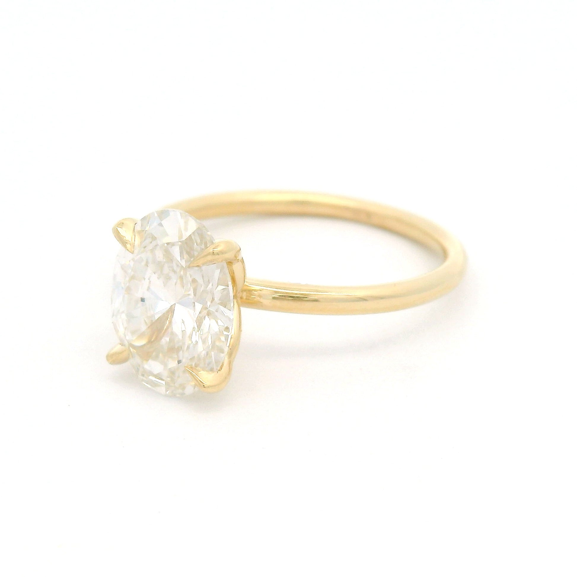 14K yellow gold solitaire engagement ring featuring a GIA certified 2.27ct lab-grown oval diamond in a claw setting on a delicate 1.7mm round wire band.