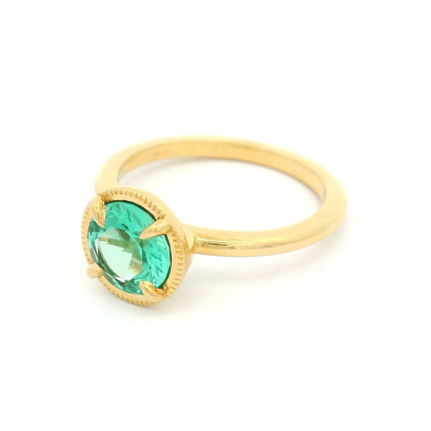 18K yellow gold solitaire ring featuring a 0.98ct round green beryl in a 4-claw setting with milgrain-framed detail on a slim band.