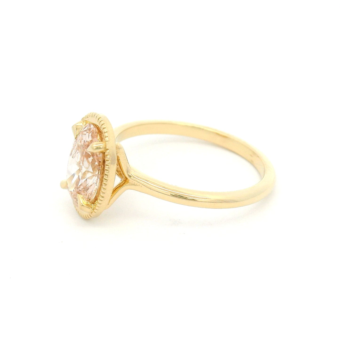 14K yellow gold solitaire engagement ring featuring a 1.50ct lab-grown oval-cut pink diamond in four-claw setting with milgrain edge and 1.8mm band.