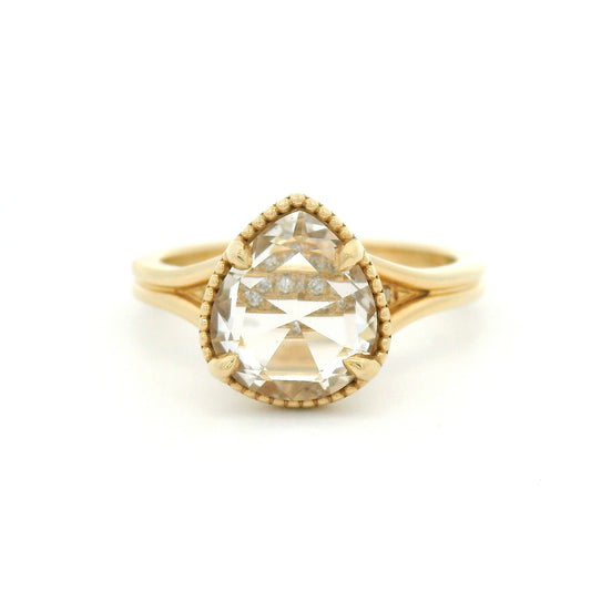 14K yellow gold engagement ring featuring a 2.01ct lab-grown rose-cut pear-shaped white sapphire in a claw setting with milgrain border and hidden bead-set lab-grown diamond accents visible through the centre stone.