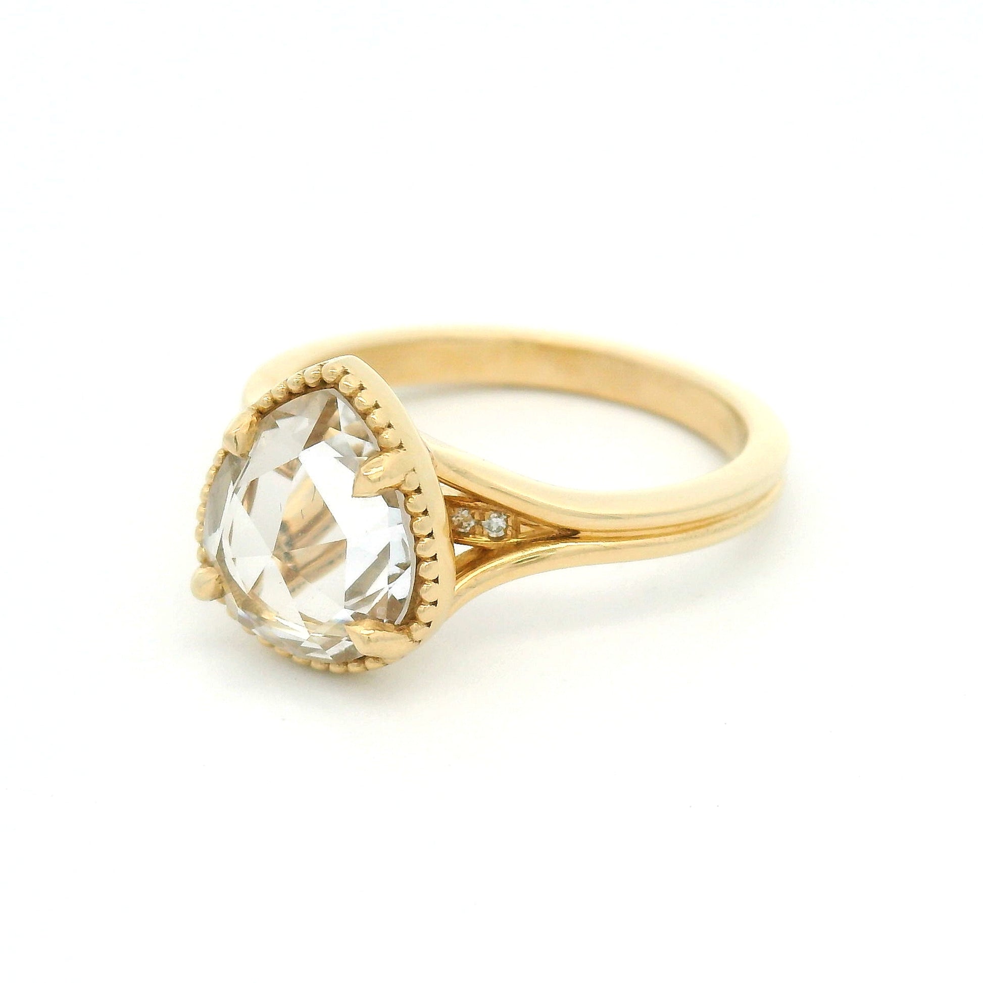 14K yellow gold engagement ring featuring a 2.01ct lab-grown rose-cut pear-shaped white sapphire in a claw setting with milgrain border and hidden bead-set lab-grown diamond accents visible through the centre stone.