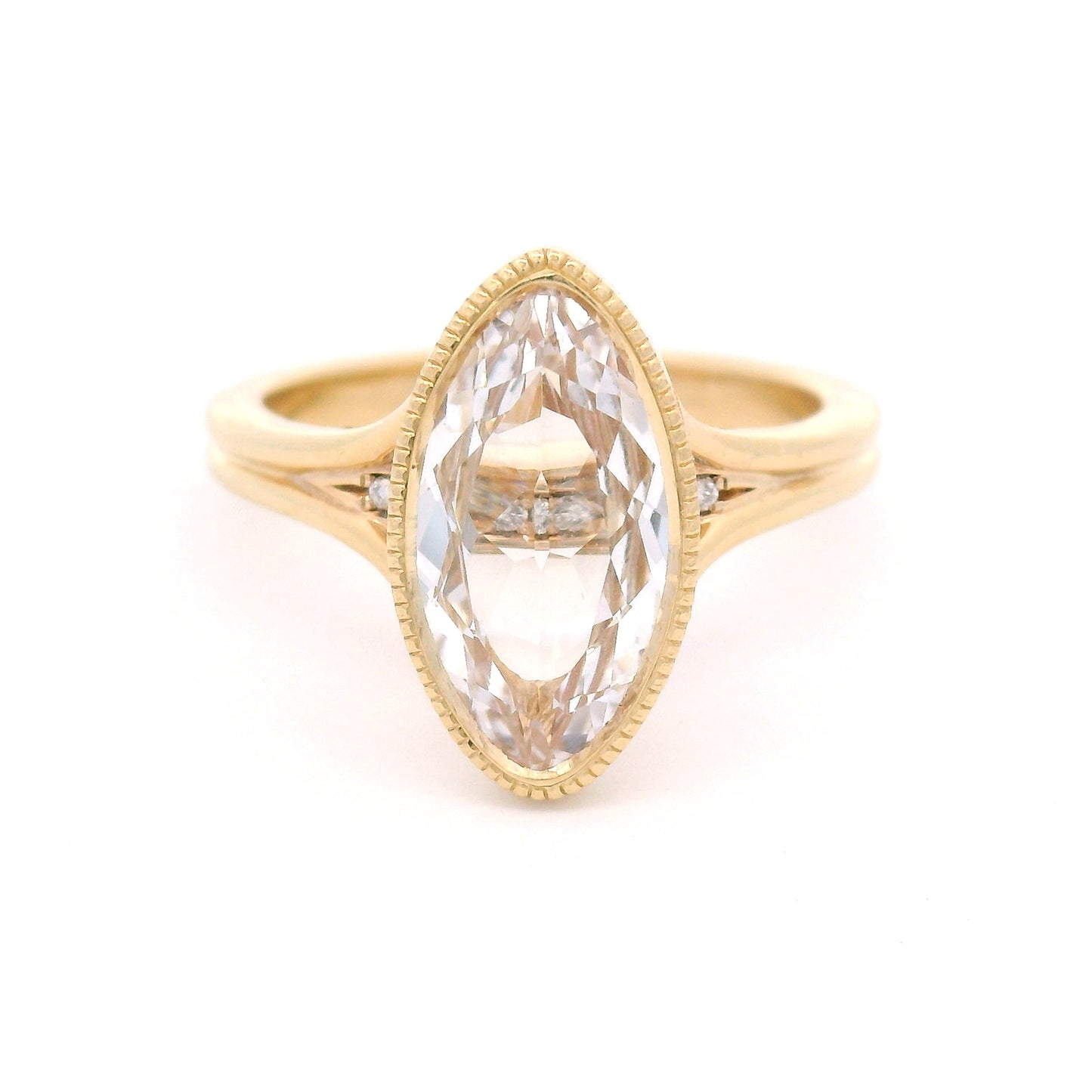 14K yellow gold engagement ring featuring a 2.75ct lab-grown marquise-oval-cut white sapphire with hidden bead-set lab-grown diamond accents in the gallery.