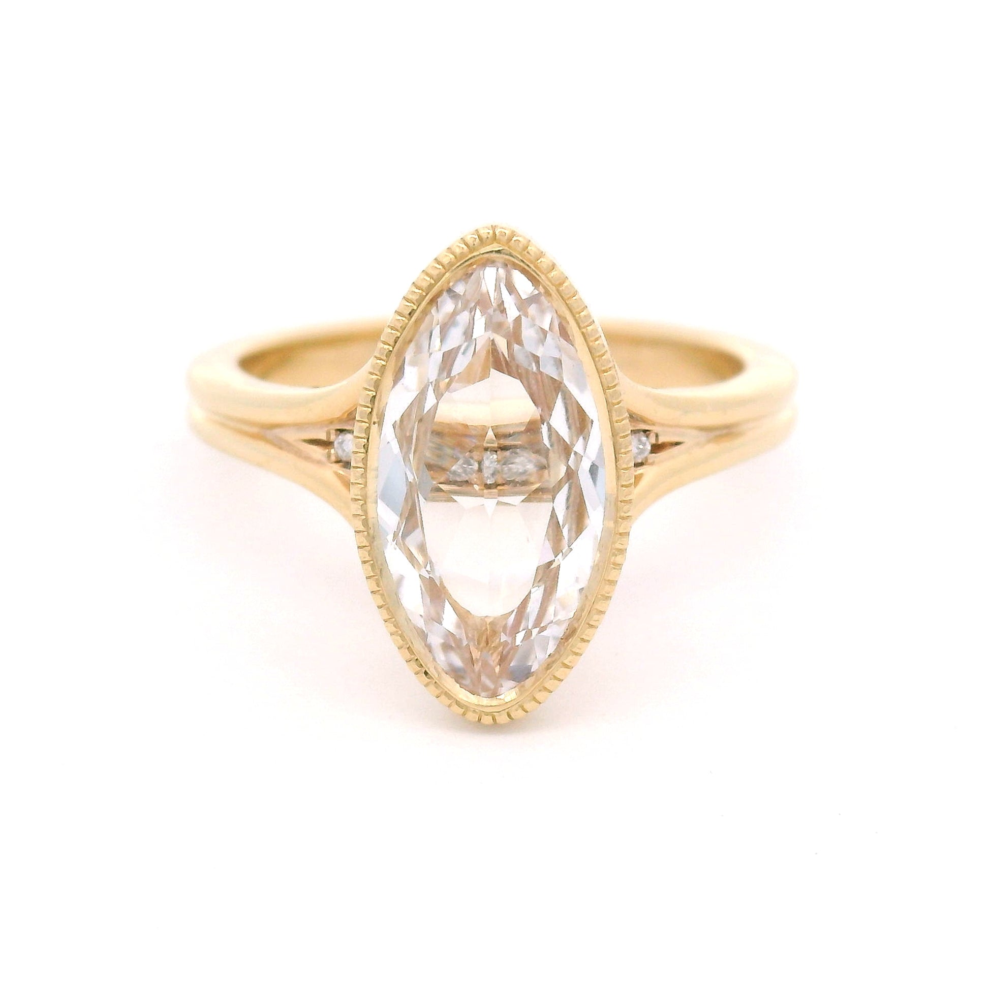 14K yellow gold engagement ring featuring a 2.75ct lab-grown marquise-oval-cut white sapphire with hidden bead-set lab-grown diamond accents in the gallery.