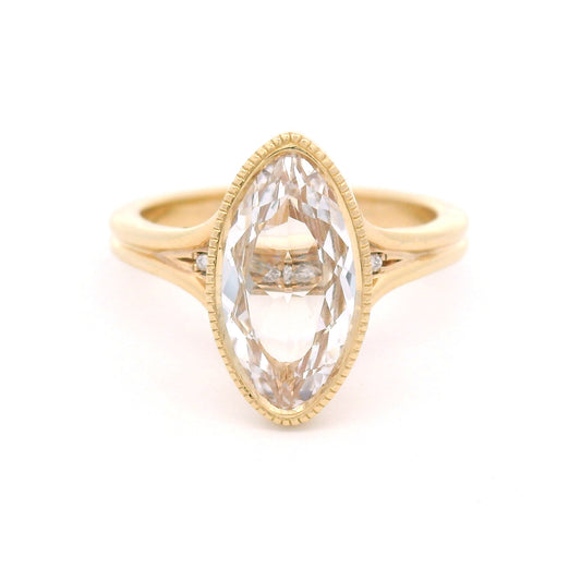 14K yellow gold engagement ring featuring a 2.75ct lab-grown marquise-oval-cut white sapphire with hidden bead-set lab-grown diamond accents in the gallery.