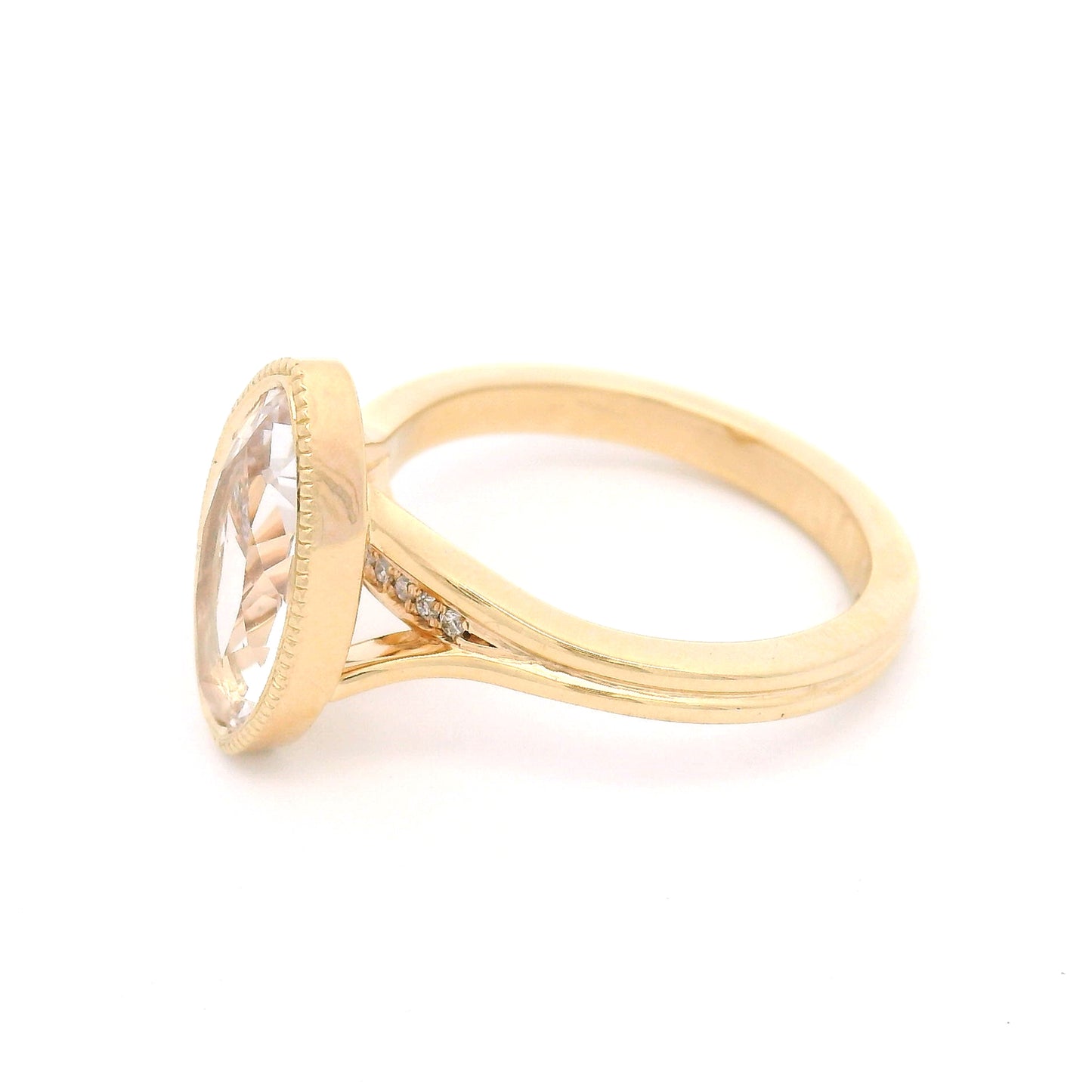 14K yellow gold engagement ring featuring a 2.75ct lab-grown moval-cut white sapphire with hidden bead-set lab-grown diamond accents in the gallery.