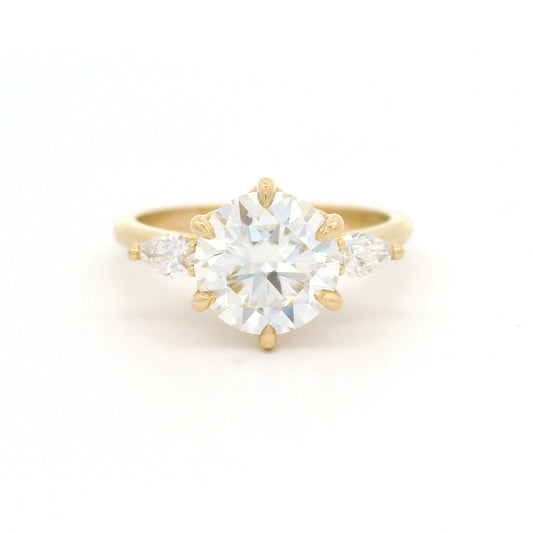 14K yellow gold three-stone engagement ring with a 1.77ct round moissanite and two pear lab-grown diamonds totalling 0.20cts.