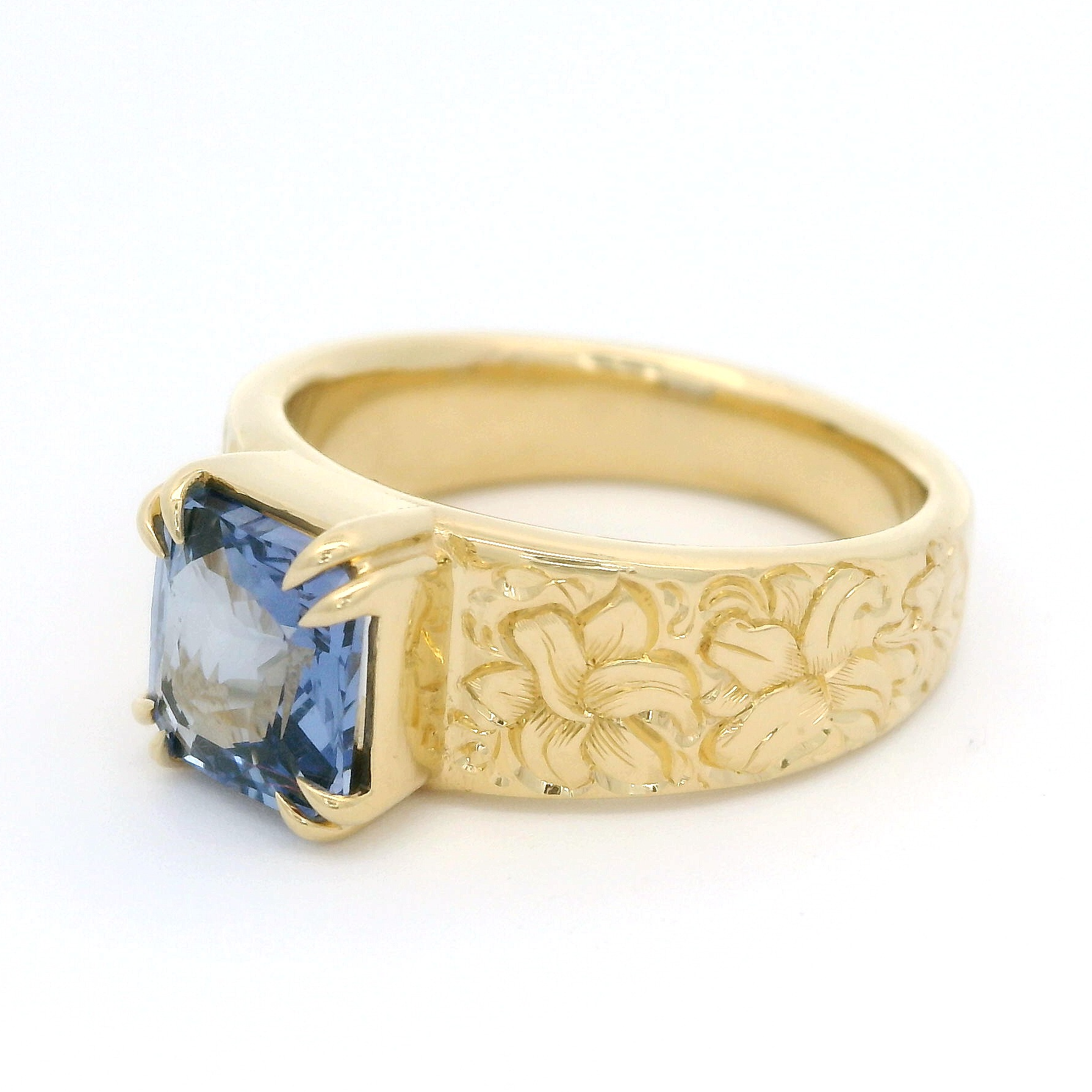 18k Yellow Gold Ring with 2.06ct Blue Sapphire and hand engraved lilies.  Shown from the side.
