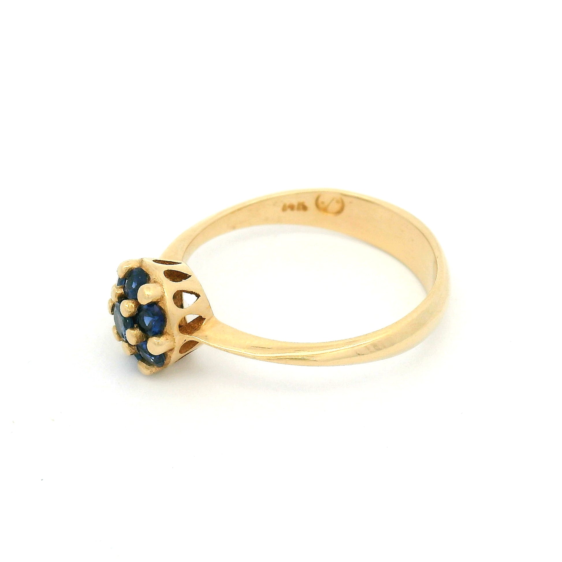 14K yellow gold engagement ring with a cluster of seven claw-set round blue sapphires measuring just over 7mm.