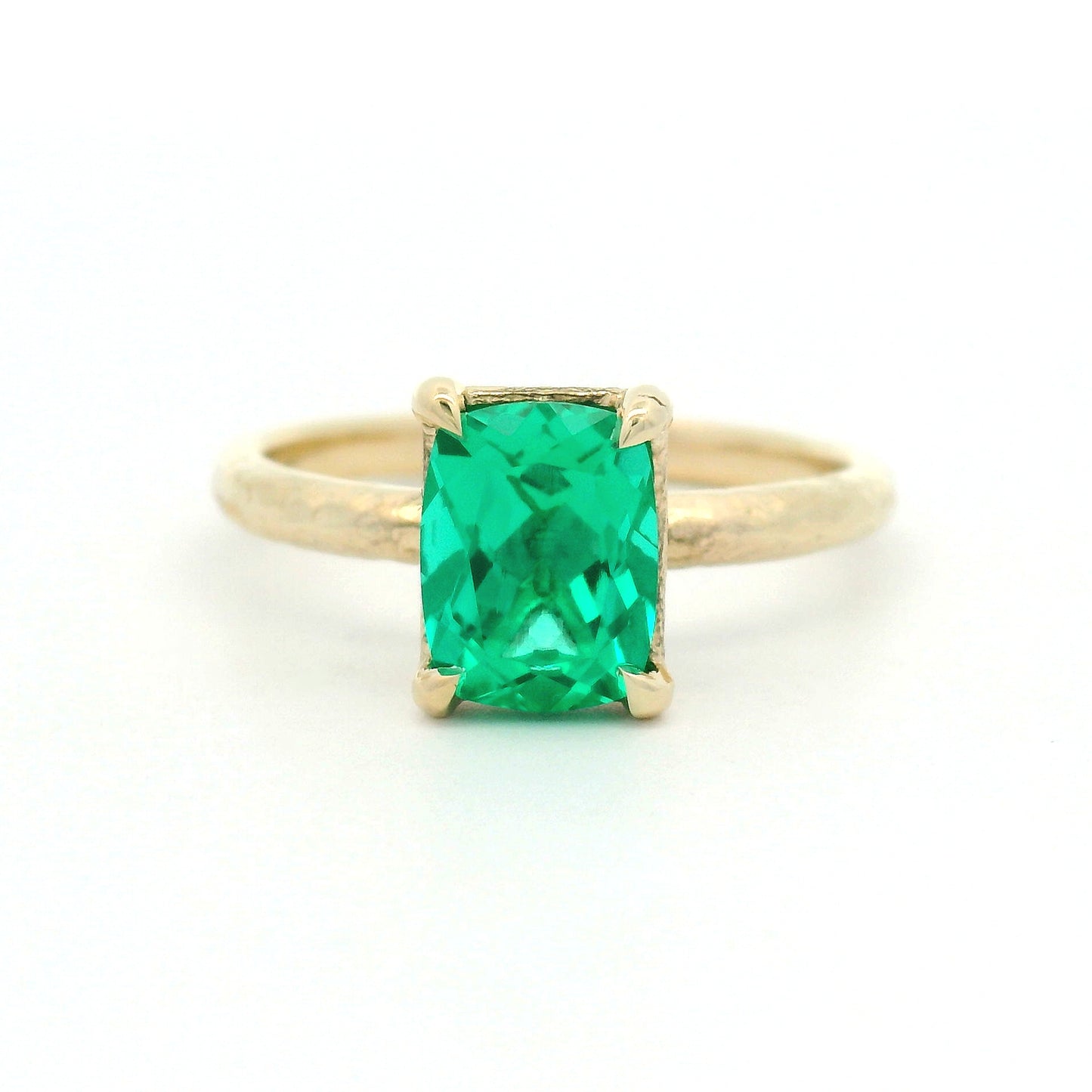 14K yellow gold organic textured solitaire engagement ring with a 1.35ct lab-grown cushion-cut emerald in a four-claw setting.