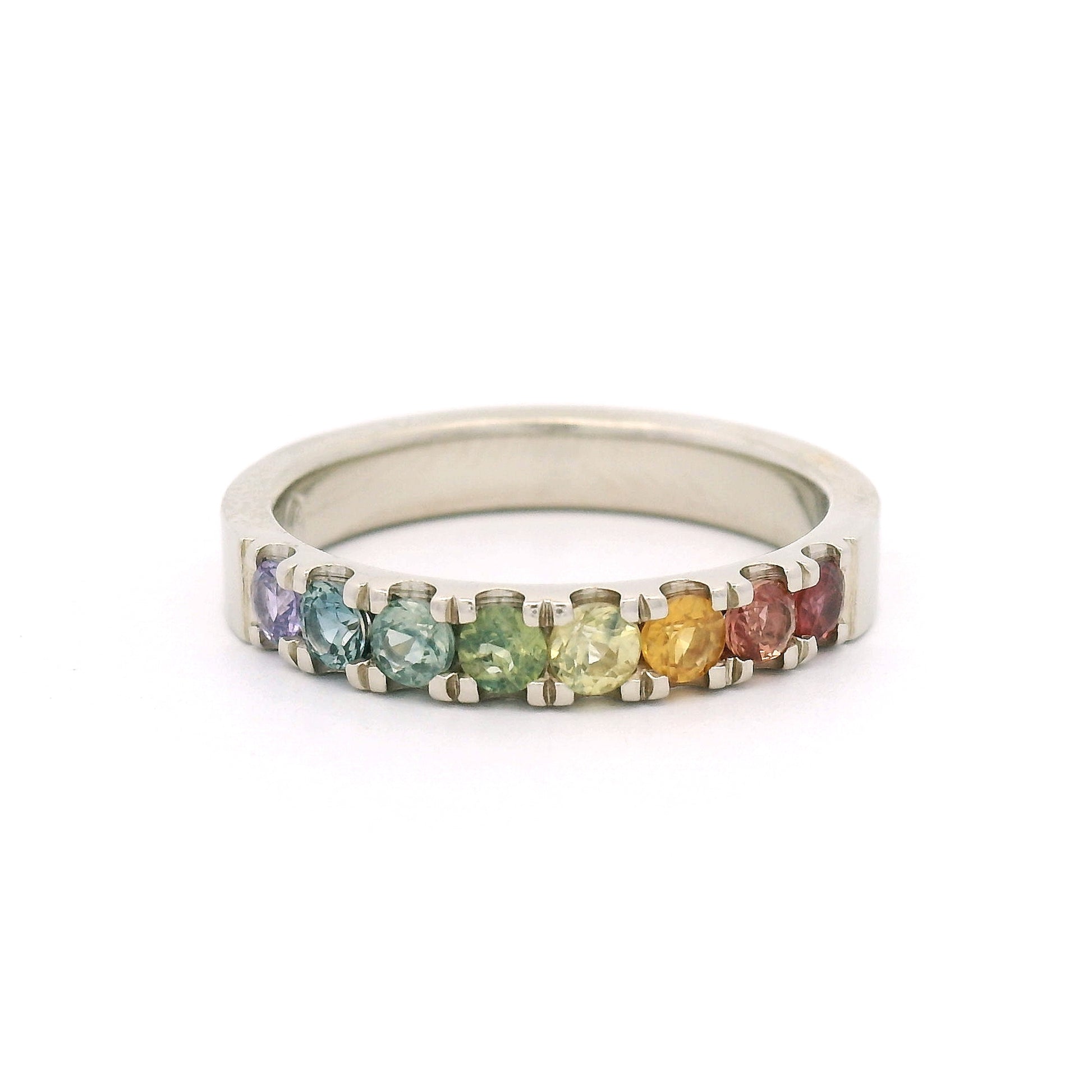 14K white gold rainbow band by Aimee Kennedy with eight 2.8mm round bead-set sapphires in rainbow colours and cut-through scalloped sides.
