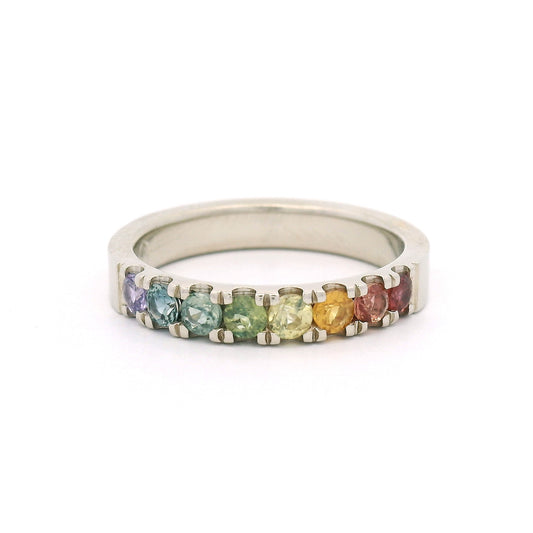 14K white gold rainbow band by Aimee Kennedy with eight 2.8mm round bead-set sapphires in rainbow colours and cut-through scalloped sides.