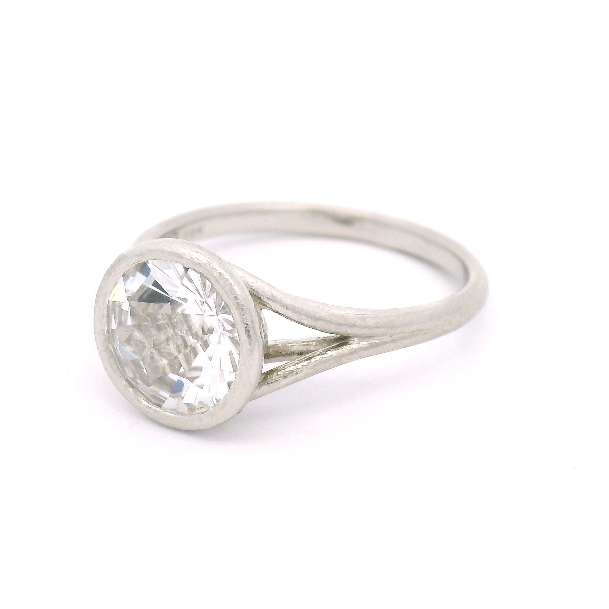 10K white gold solitaire ring featuring a bezel-set 2.57ct lab-grown round rose-cut white sapphire with a delicate organic split shank.