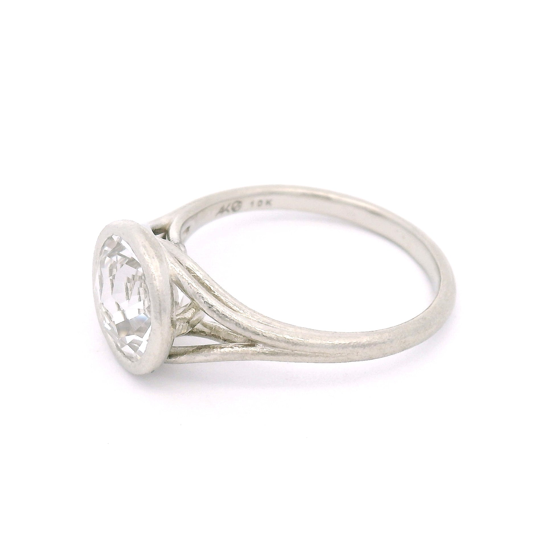 10K white gold solitaire ring featuring a bezel-set 2.57ct lab-grown round rose-cut white sapphire with a delicate organic split shank.