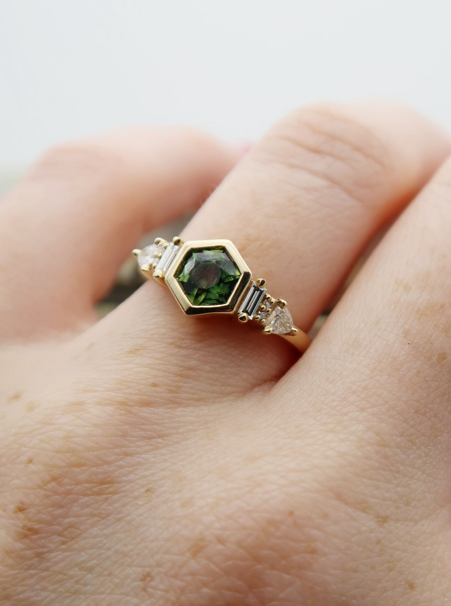 14K 0.88ct Australian green sapphire lab diamond accent engagement ring.  Worn on a finger.