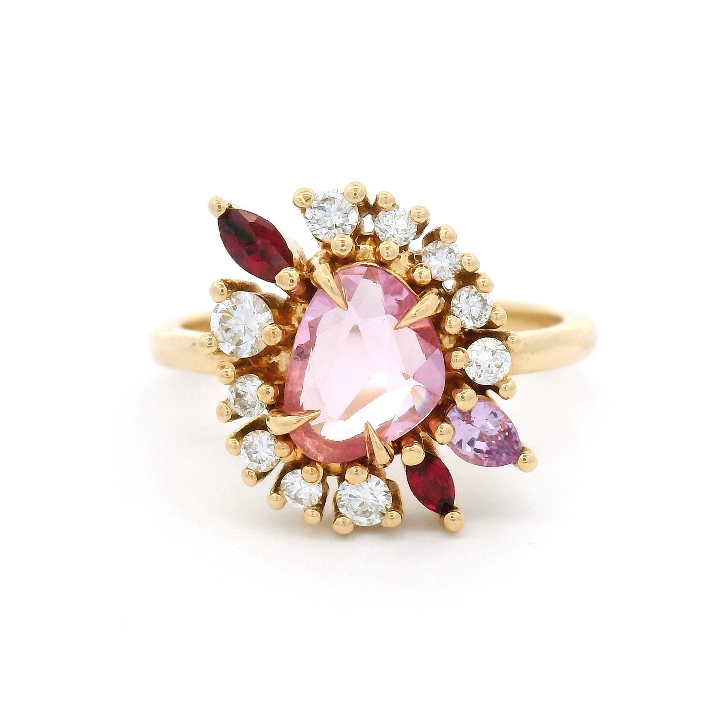 14K yellow gold asymmetrical engagement ring featuring a natural 0.70ct triangular pink sapphire with a halo of mixed-cut pink sapphires, rubies, and lab-grown diamonds totalling 0.23cts.