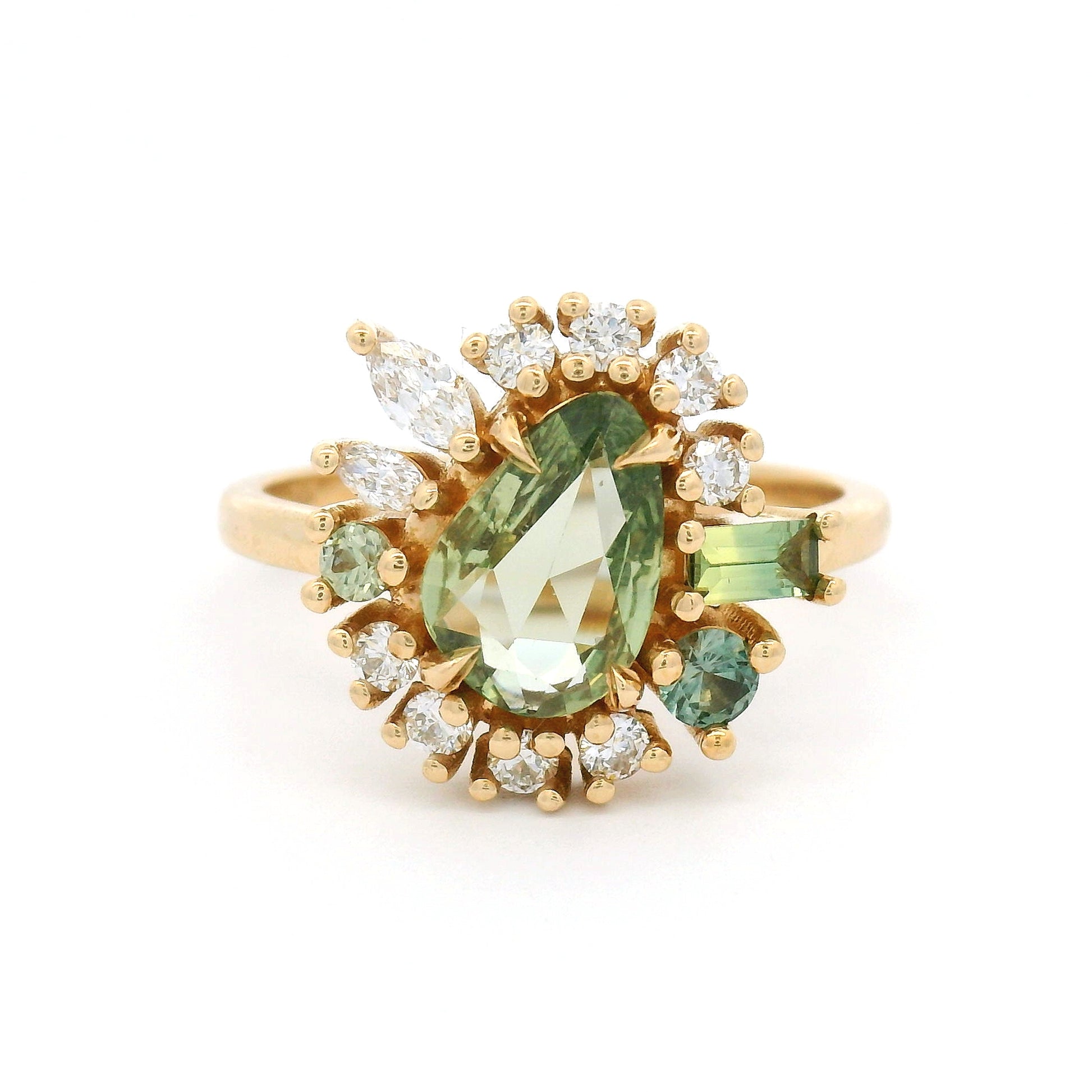 14K yellow gold asymmetrical engagement ring featuring a natural 0.90ct triangular green sapphire with a halo of mixed-cut green sapphires and lab-grown diamonds totalling 0.55cts.
