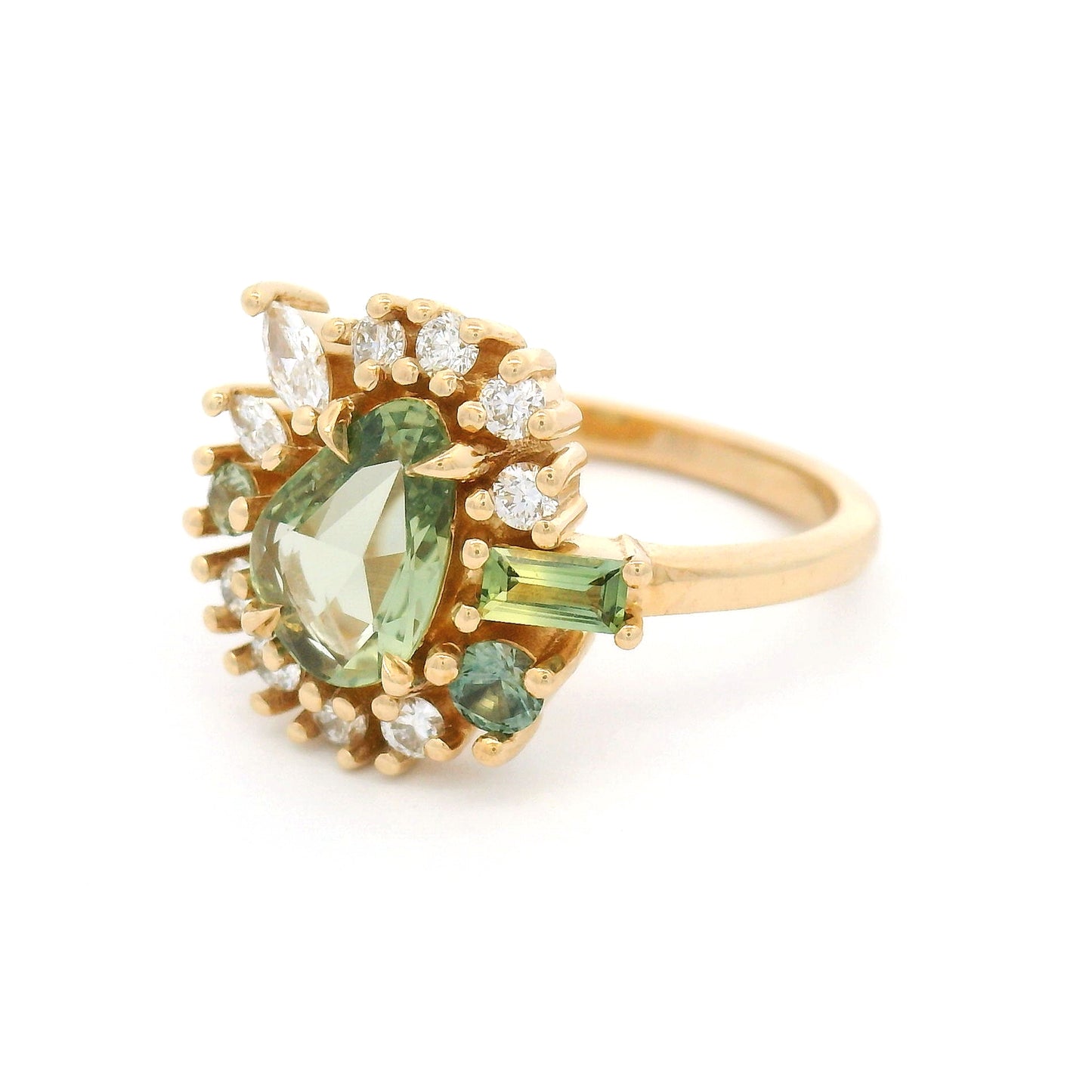 14K yellow gold asymmetrical engagement ring featuring a natural 0.90ct triangular green sapphire with a halo of mixed-cut green sapphires and lab-grown diamonds totalling 0.55cts.