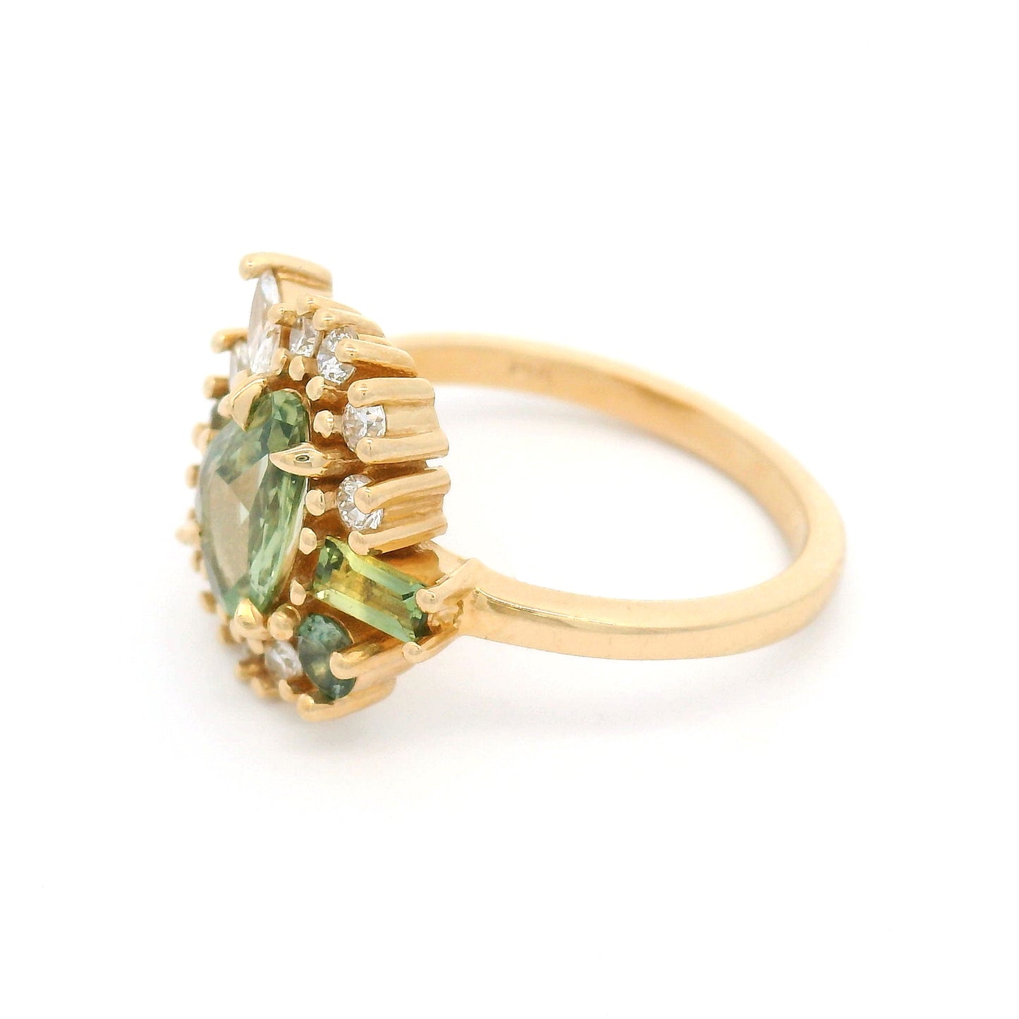 14K yellow gold asymmetrical engagement ring featuring a natural 0.90ct triangular green sapphire with a halo of mixed-cut green sapphires and lab-grown diamonds totalling 0.55cts.