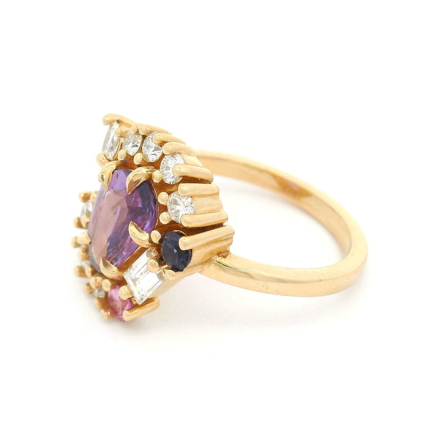14K yellow gold asymmetrical engagement ring featuring a natural 1.01ct triangular purple sapphire with a halo of mixed-cut pink and purple sapphires and lab-grown diamonds totalling 0.93cts.