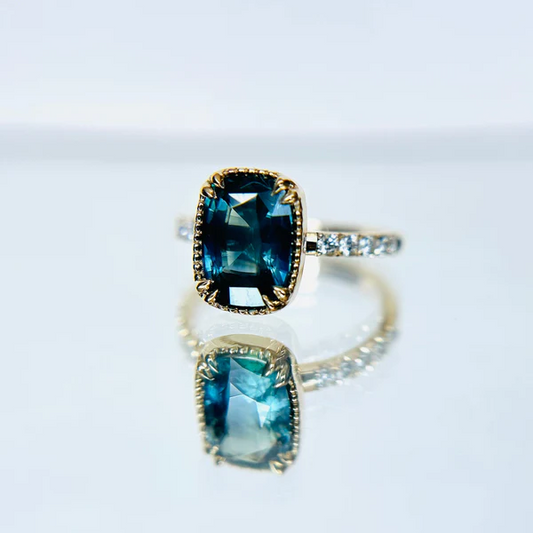14k yellow gold ring set with sapphire cushion cut and accent white diamonds.