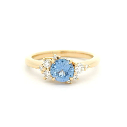 14K yellow gold engagement ring with a natural 0.82ct unheated round Sri Lankan cornflower blue sapphire and asymmetrical scatter of eight natural diamonds.
