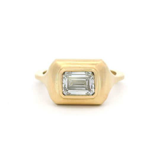 10K yellow gold bezel-set solitaire engagement ring with a 1.02ct lab-grown emerald-cut diamond, VVS2 clarity, D colour and satin-finished sculpted setting.
