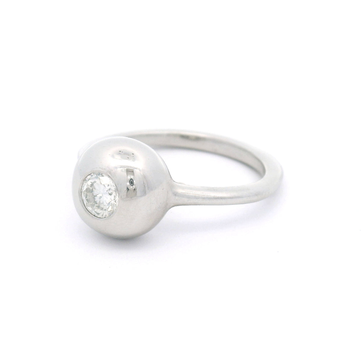 Platinum bezel-set solitaire ring with a natural 0.30ct round brilliant-cut diamond, I1 clarity, K colour, rounded dome and 1.5mm band.