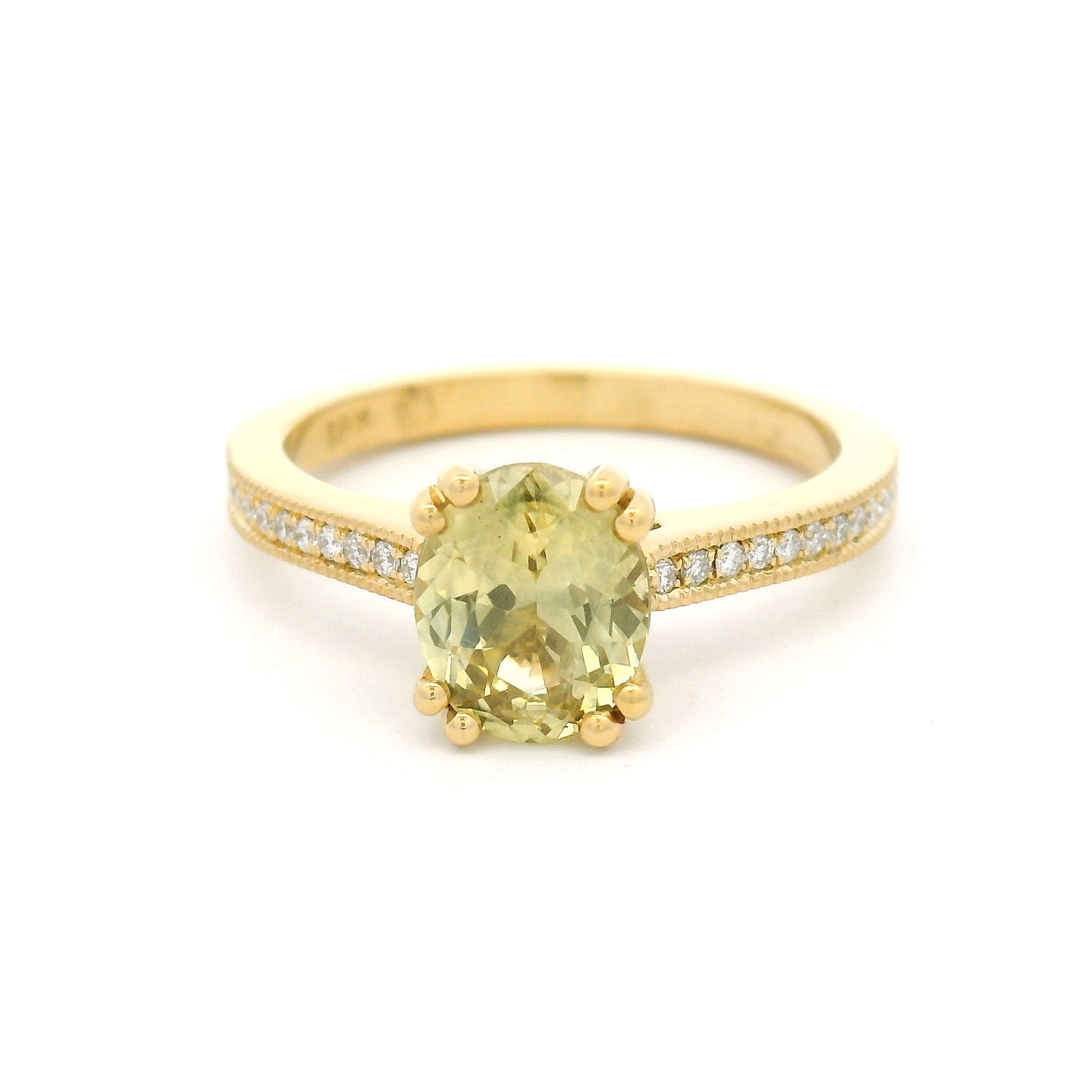 18K yellow gold engagement ring with a double claw-set 1.49ct natural oval yellow sapphire, bead-set natural diamond shoulders, and milgrain edges.