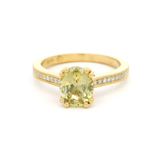 18K yellow gold engagement ring with a double claw-set 1.49ct natural oval yellow sapphire, bead-set natural diamond shoulders, and milgrain edges.