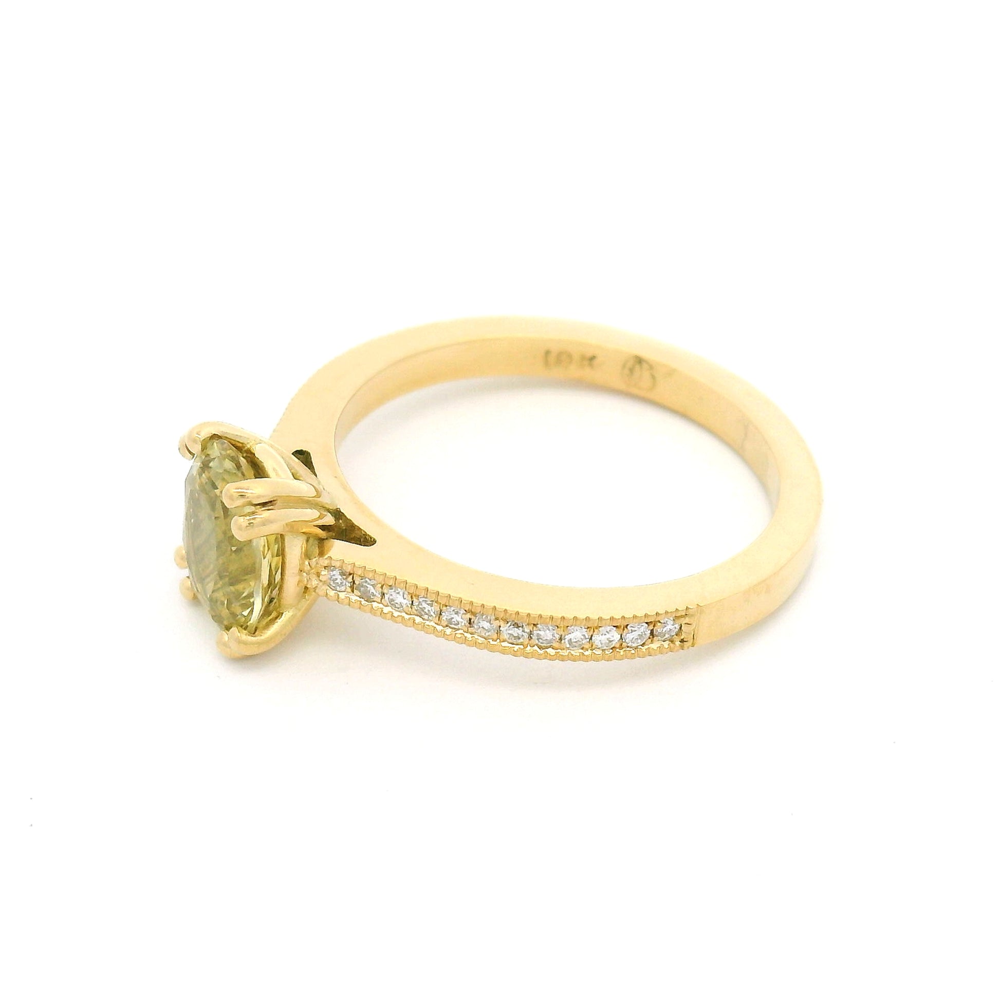 18K yellow gold engagement ring with a double claw-set 1.49ct natural oval yellow sapphire, bead-set natural diamond shoulders, and milgrain edges.
