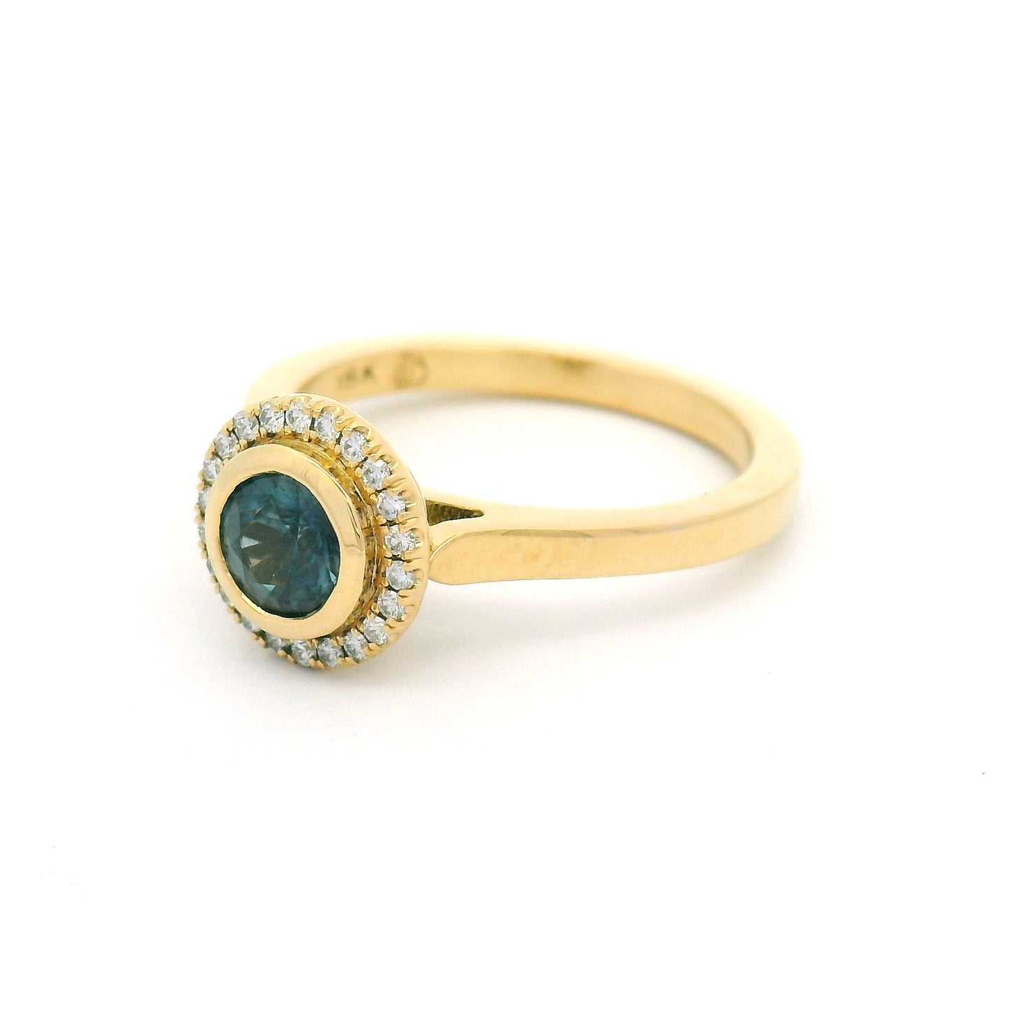 18K yellow gold engagement ring with a bezel-set natural 0.65ct round teal sapphire and bead-set halo of 0.12cts natural diamonds.
