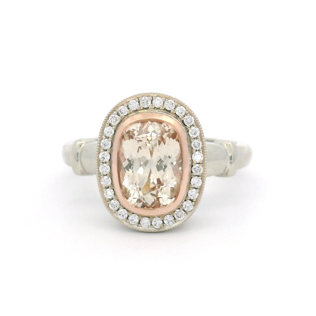 18K white gold engagement ring with a 14K rose gold bezel, natural 1.95ct cushion-cut peach sapphire, 28 natural diamonds and wire undergallery details.