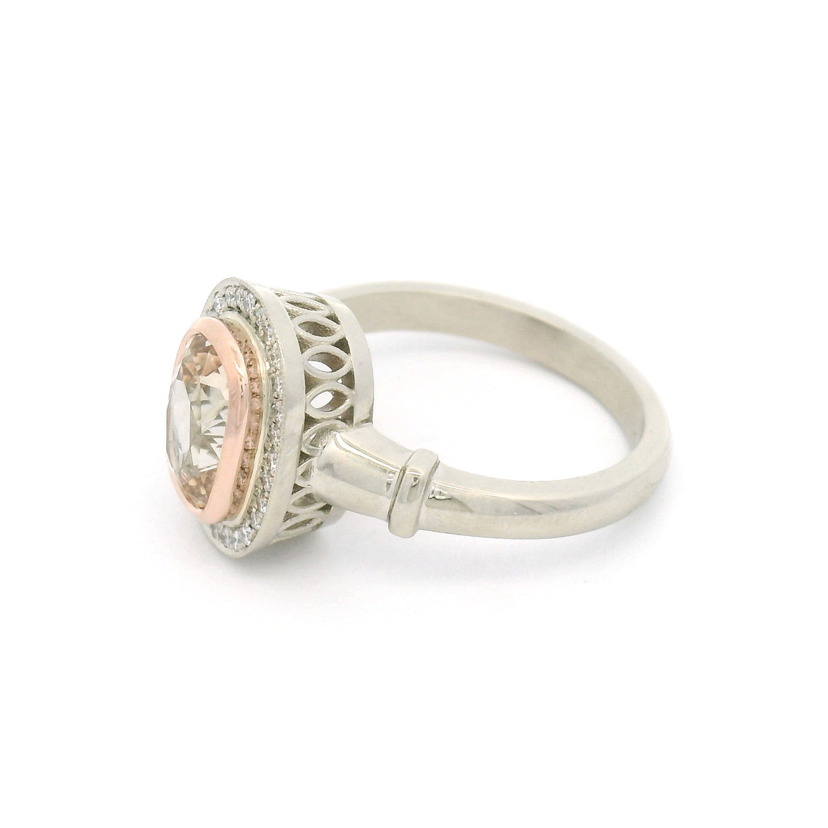 18K white gold engagement ring with a 14K rose gold bezel, natural 1.95ct cushion-cut peach sapphire, 28 natural diamonds and wire undergallery details.