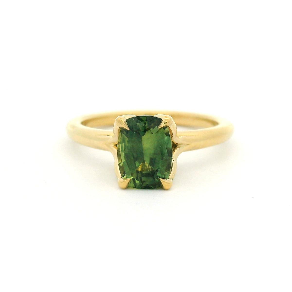 18K yellow gold four-claw solitaire engagement ring with a natural 1.54ct cushion-cut green sapphire, 1.8mm band and fine wire leaf details beneath the stone.
