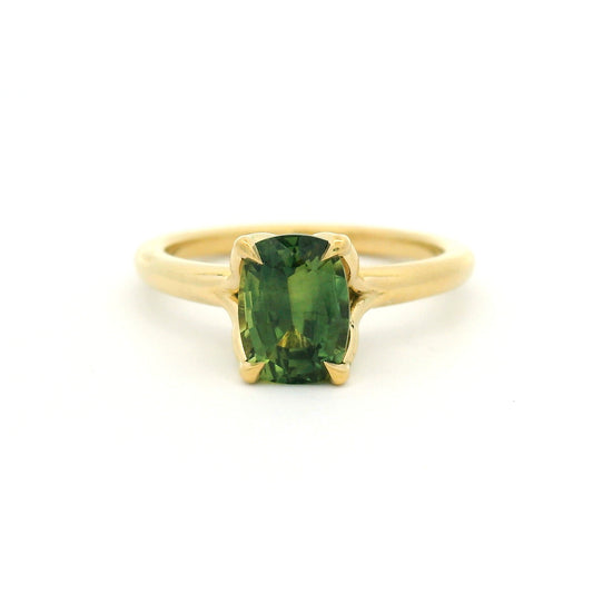 18K yellow gold four-claw solitaire engagement ring with a natural 1.54ct cushion-cut green sapphire, 1.8mm band and fine wire leaf details beneath the stone.