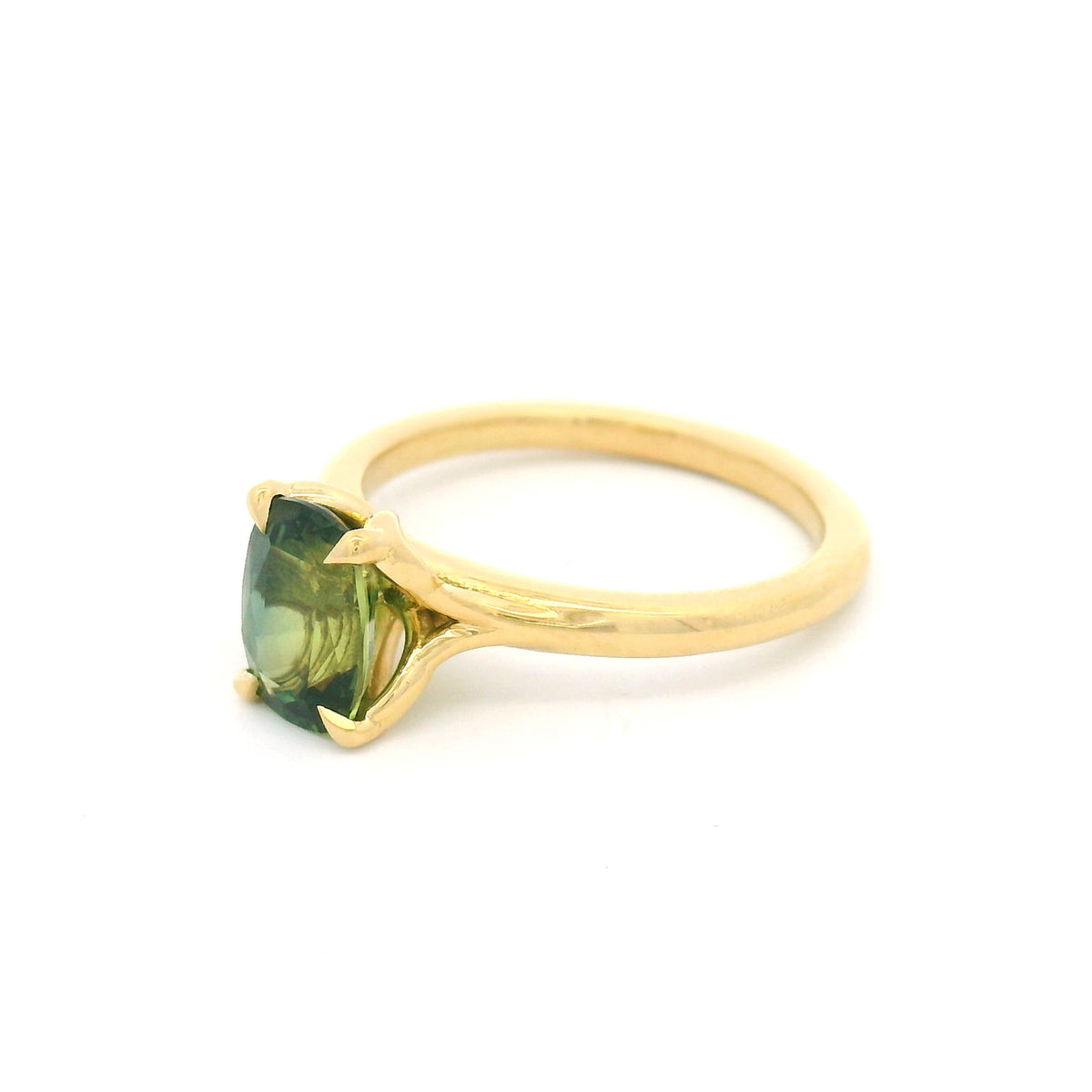 18K yellow gold four-claw solitaire engagement ring with a natural 1.54ct cushion-cut green sapphire, 1.8mm band and fine wire leaf details beneath the stone.