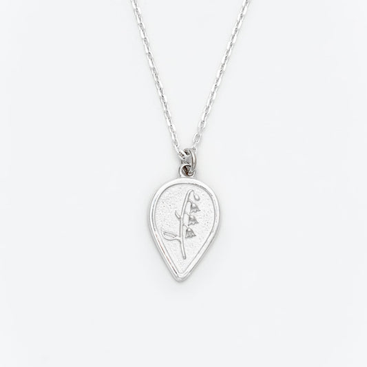 Silver necklace with a teardrop-shaped pendant on a white background